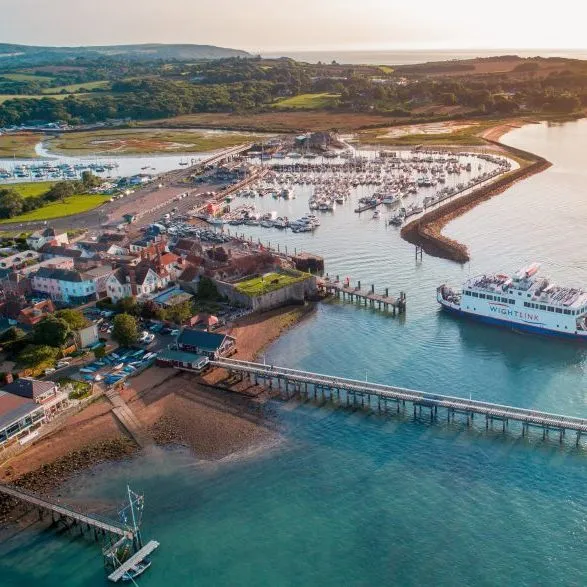 Aerial view of Yarmouth harbour with marina, pier and a ferry entering the harbour at sunset