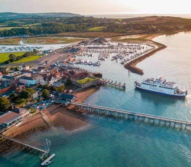 Aerial view of Yarmouth harbour with marina, pier and a ferry entering the harbour at sunset