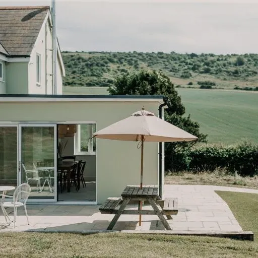 Cottage patio with picnic table and parasol overlooking rolling countryside