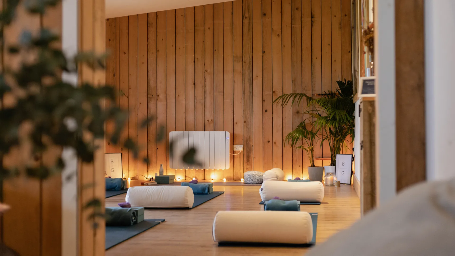 Yoga studio set up with mats and bolsters in a warm wooden room at Tapnell Farm