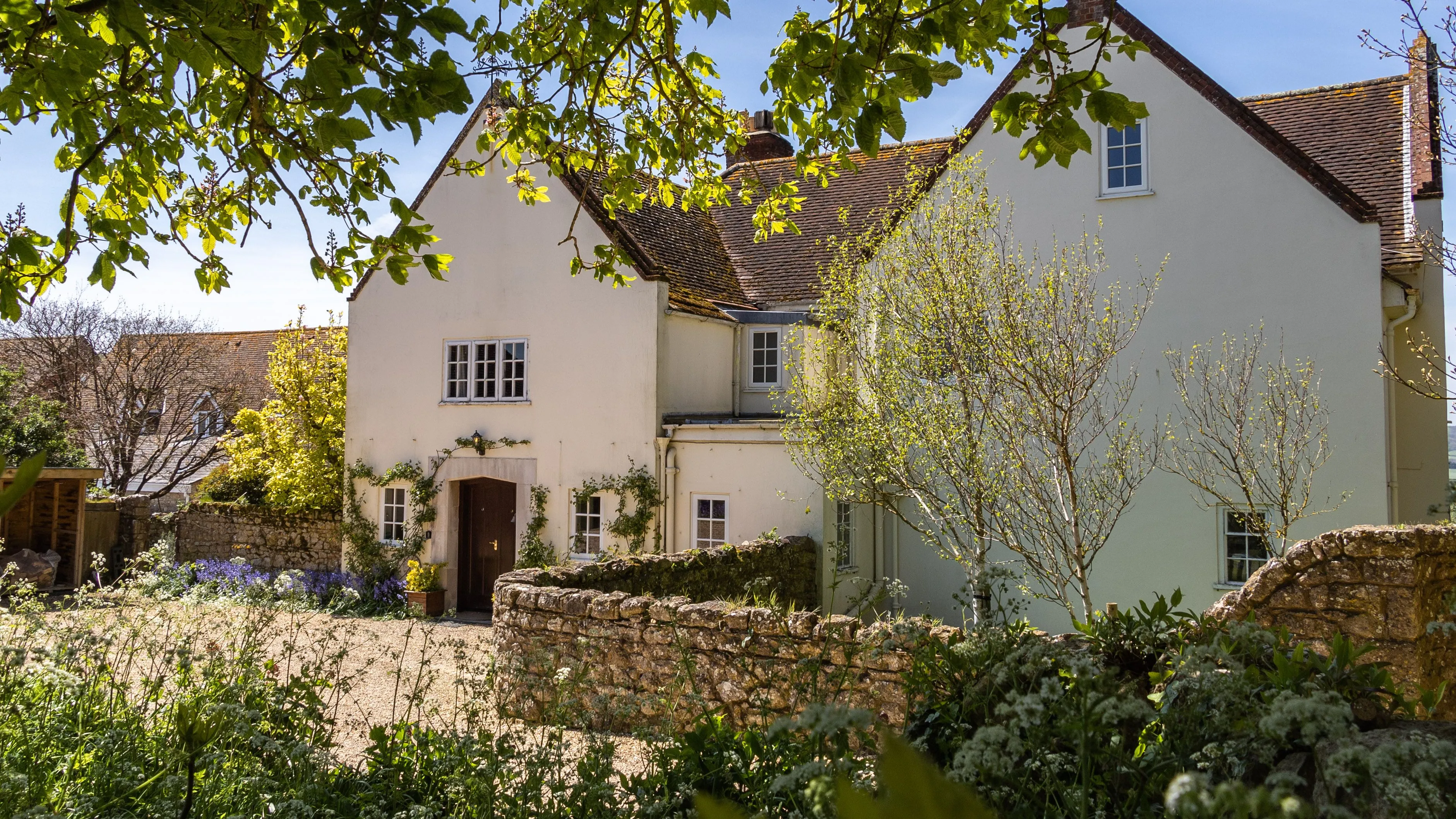 Manor House at Tapnell Farm with spring gardens and leafy trees