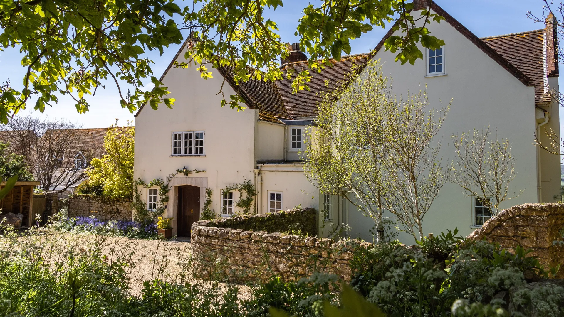 Manor House at Tapnell Farm with spring gardens and leafy trees