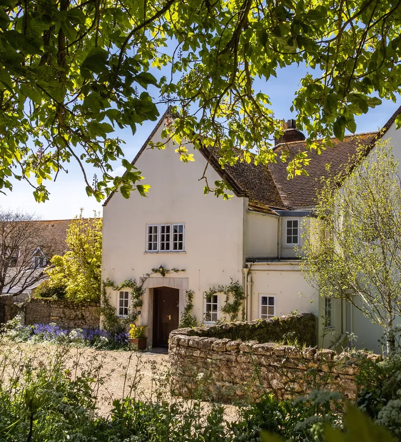 Manor House at Tapnell Farm with spring gardens and leafy trees