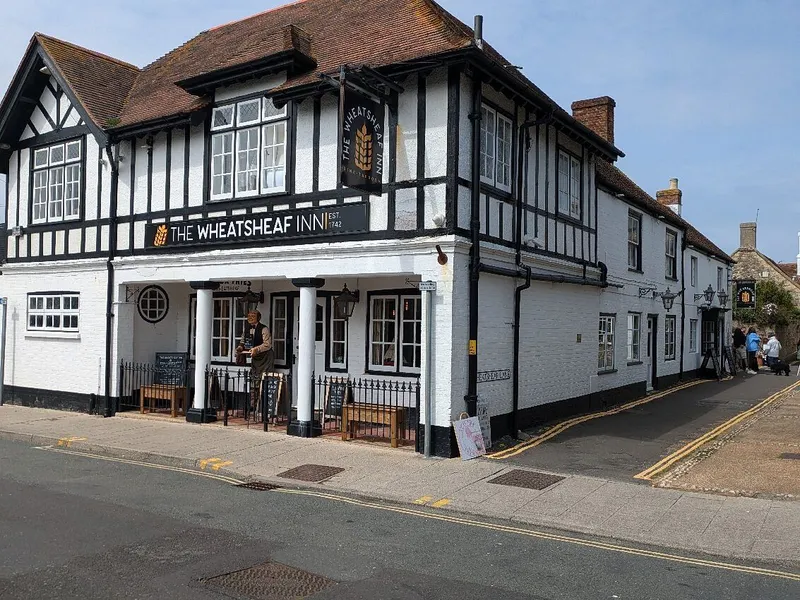Exterior view of The Wheatsheaf Inn, a traditional black-and-white timber-framed pub on a street corner.
