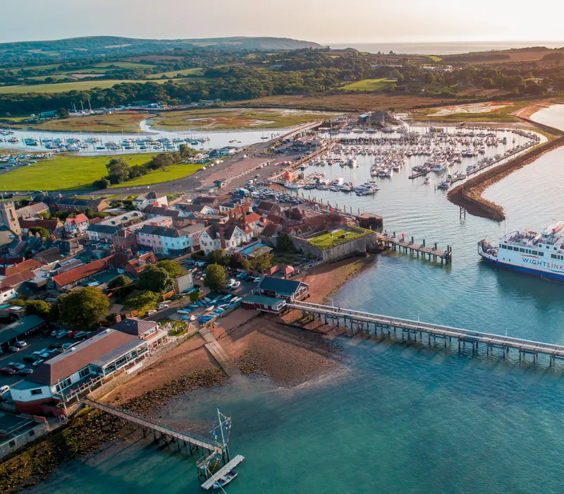 Aerial view of Yarmouth harbour with a Wightlink ferry, marina, pier and surrounding countryside on the Isle of Wight.