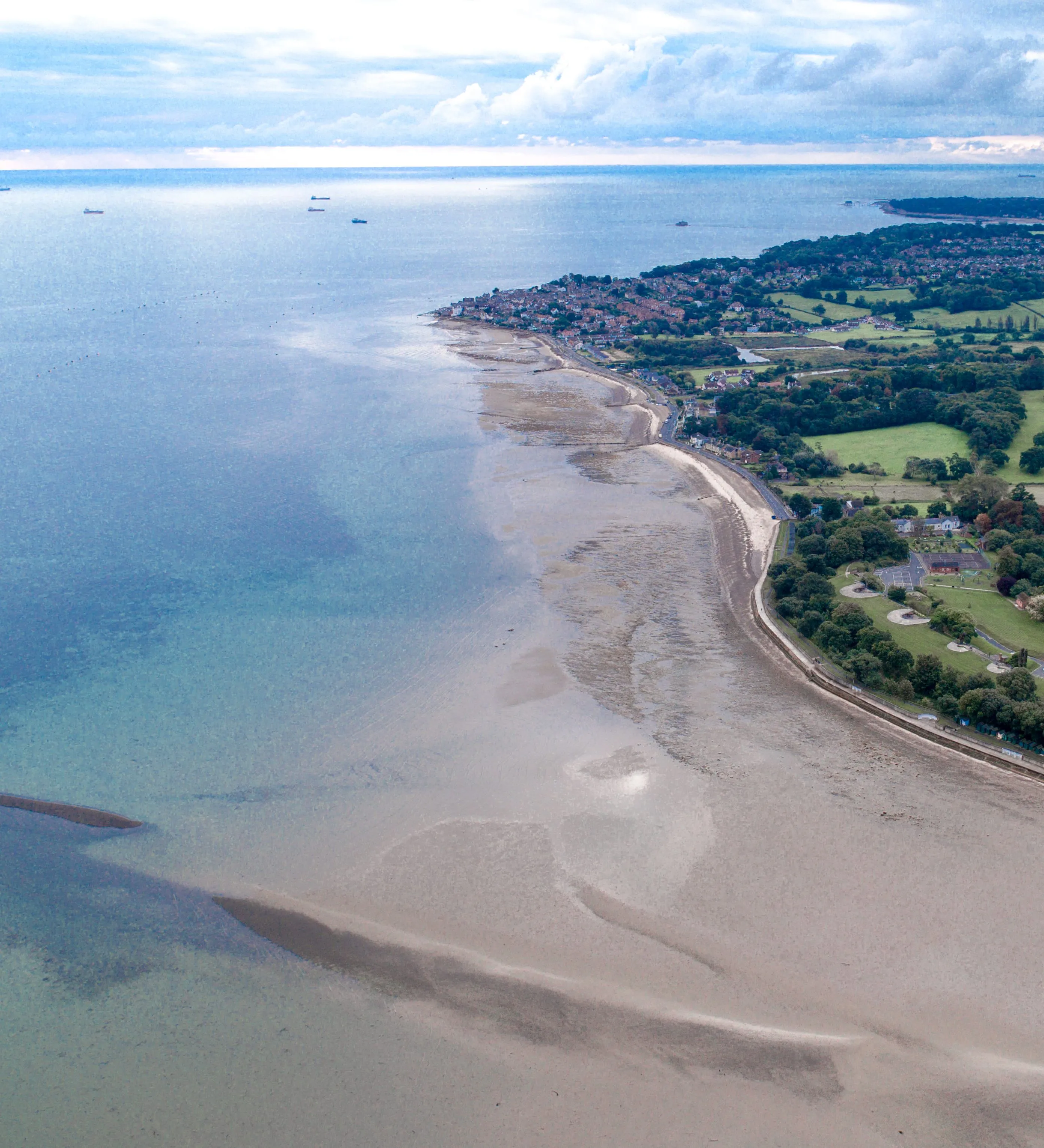 Aerial view of Appley Beach and the coastline near Ryde on the Isle of Wight at low tide, with calm sea, sandy shore and green countryside beyond.