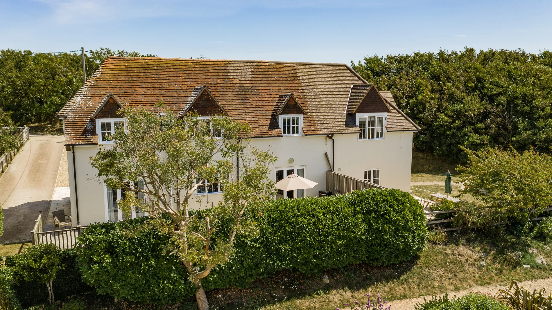 Rear view of Dairyman's Cottage at Tapnell Farm with cream exterior, tiled roof and garden patio