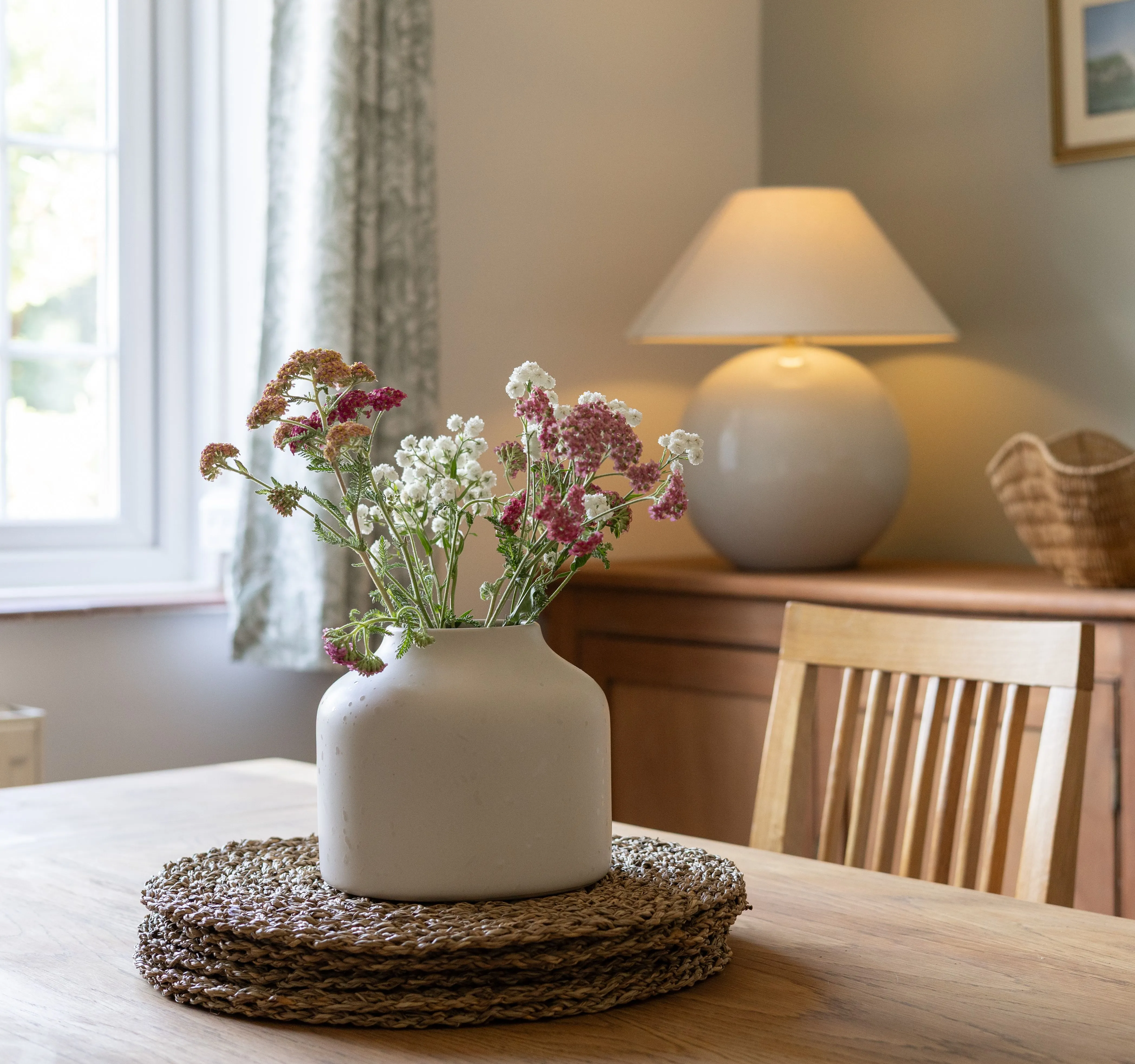 Cosy cottage dining room with a wildflower vase on a wooden table