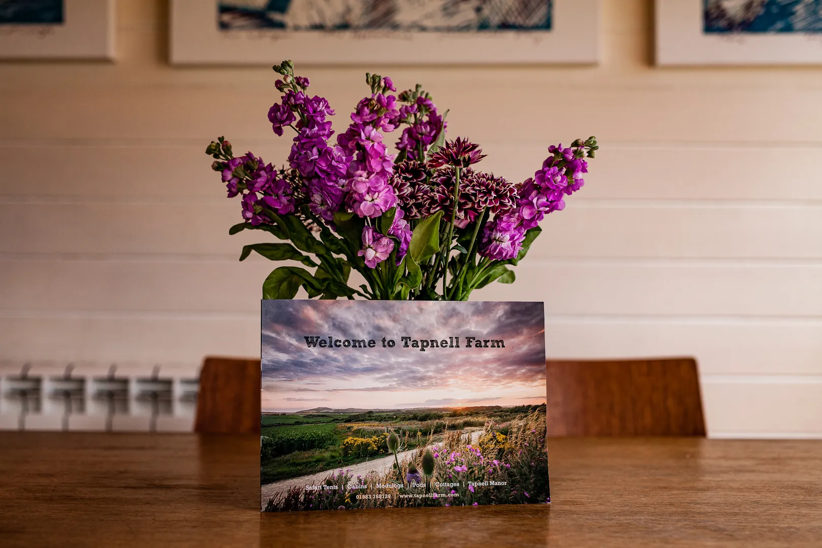 Purple flowers in a vase behind a 
