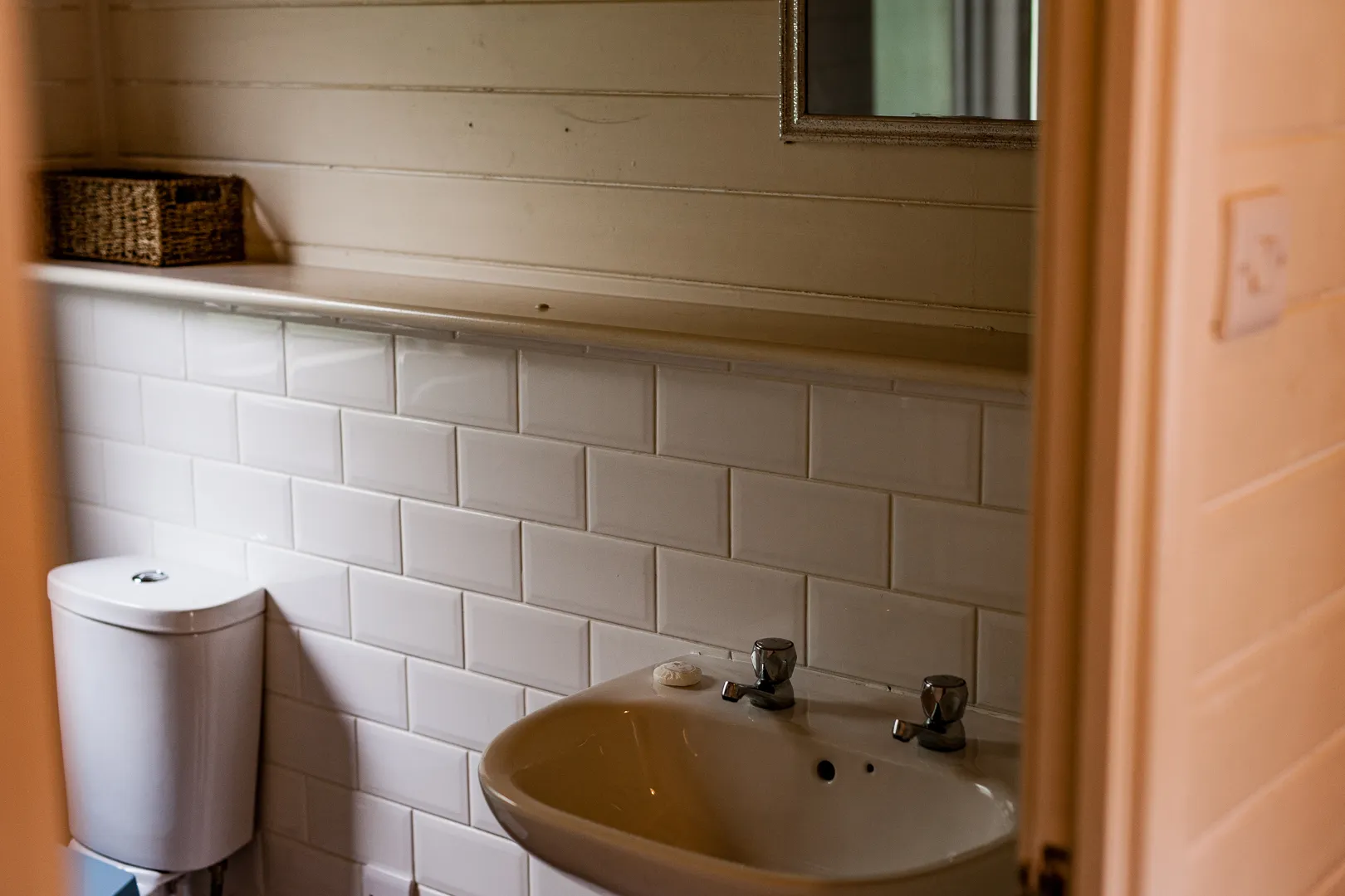 Small bathroom with white subway tiles, toilet and basin sink