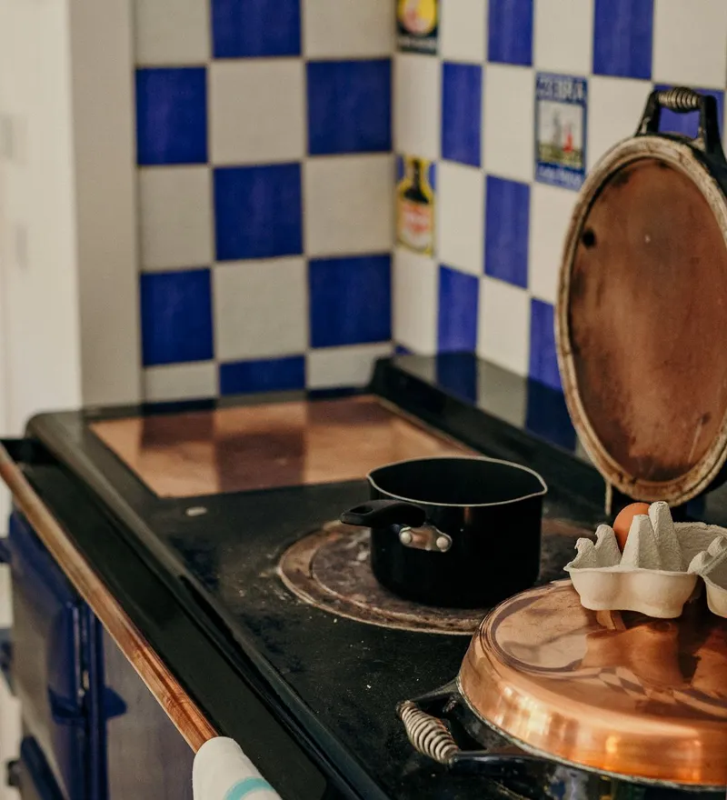Traditional range cooker with blue-and-white tiled splashback, saucepan and egg carton