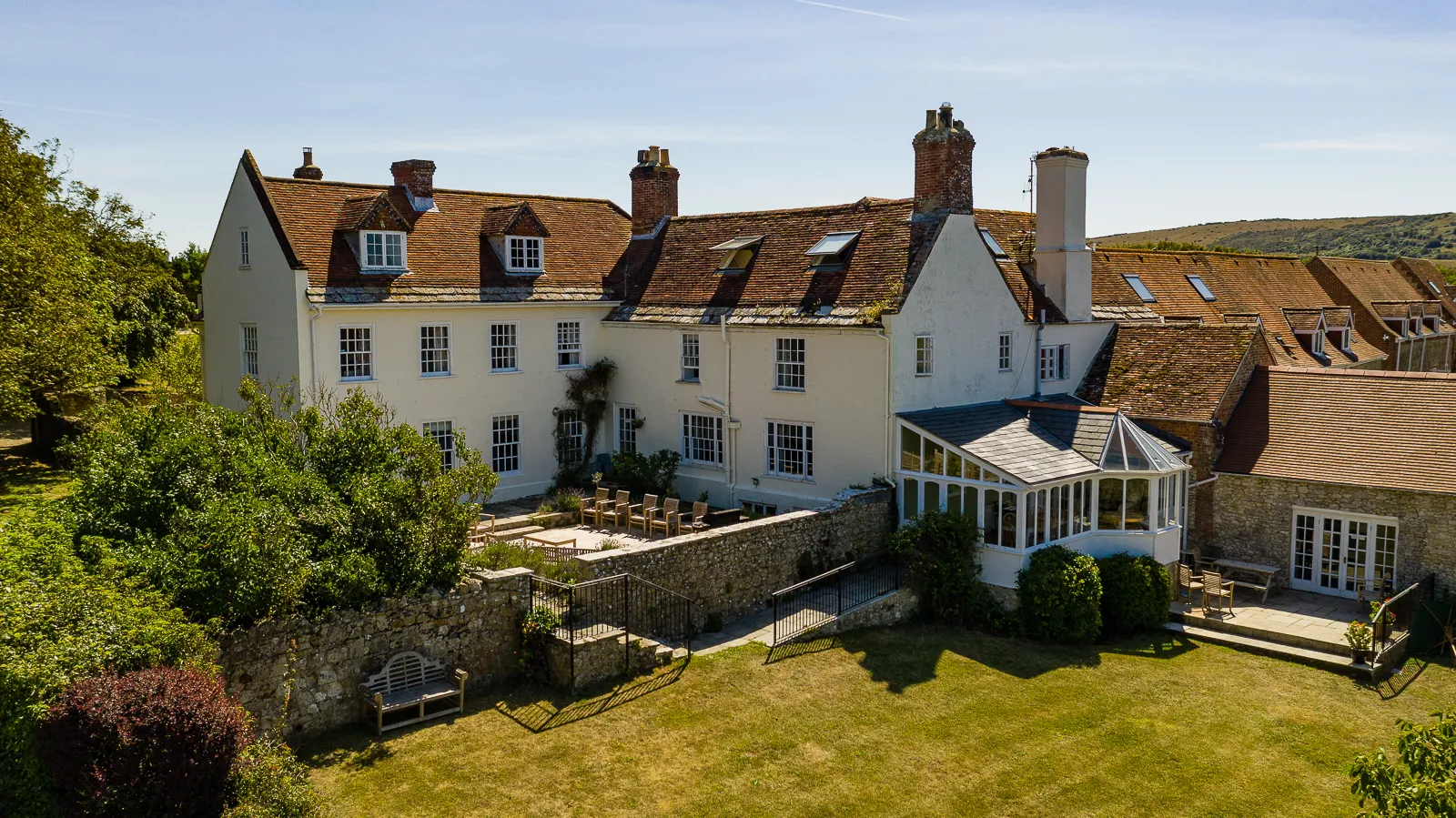 Tapnell Manor country house with terraced garden and glass conservatory on a sunny day