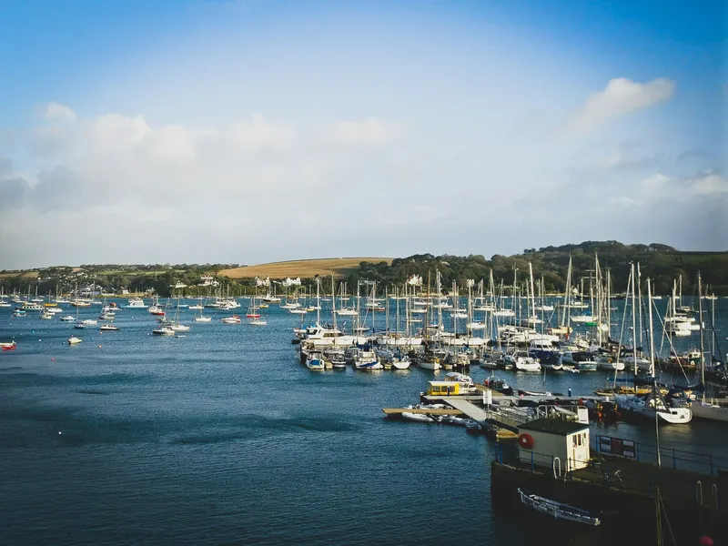 Falmouth Harbour filled with sailing boats and yachts on calm blue water beneath a bright sky