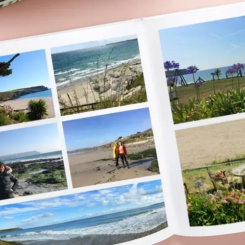 Open photo book showing beach views, purple flowers and people relaxing beside the sea