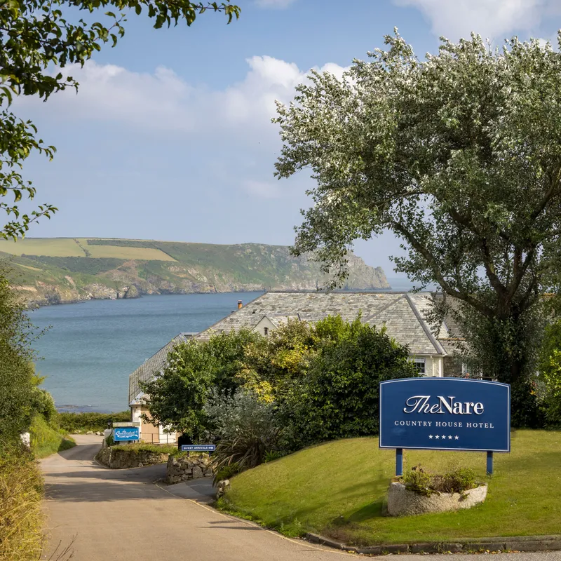 Entrance to The Nare Country House Hotel overlooking a Cornish bay and coastal cliffs
