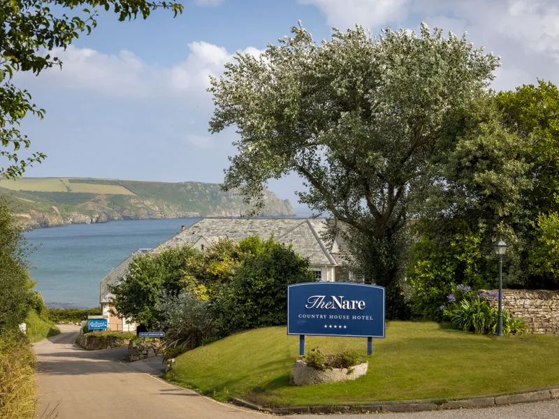 Entrance to The Nare Country House Hotel overlooking a Cornish bay and coastal cliffs
