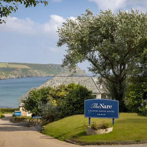 Entrance to The Nare Country House Hotel overlooking a Cornish bay and coastal cliffs