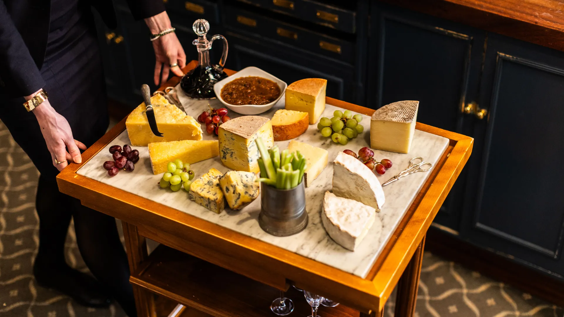 Cheese trolley with assorted cheeses, grapes, celery and chutney in a dining room