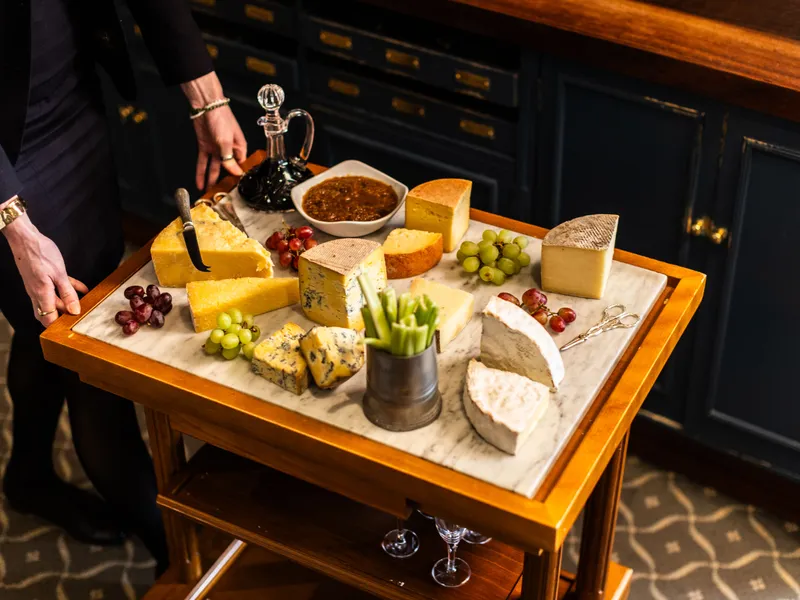Cheese trolley with assorted cheeses, grapes, celery and chutney in a dining room