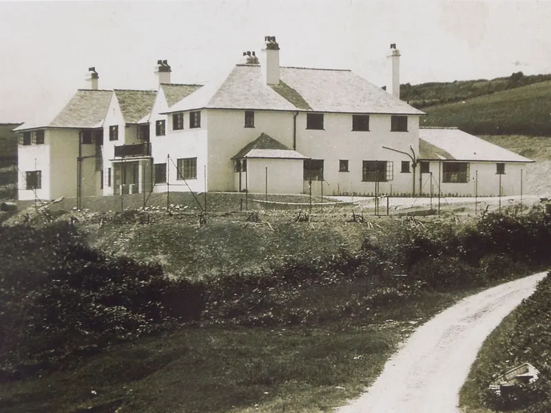 Historic photograph of The Nare hotel building with whitewashed walls, slate roofs and surrounding countryside