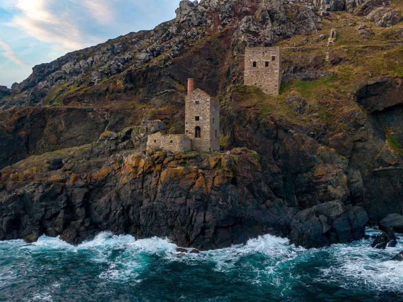 The Mines of Botallack Old stone mine buildings perched on a rugged cliff above the sea