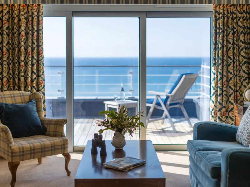 Elegant sea view suite lounge with balcony overlooking the ocean