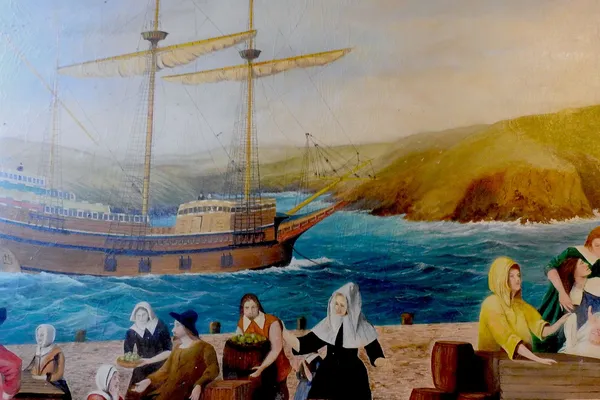 Illustration of the Mayflower anchored near a rocky shoreline, with settlers gathered on the beach in the foreground.