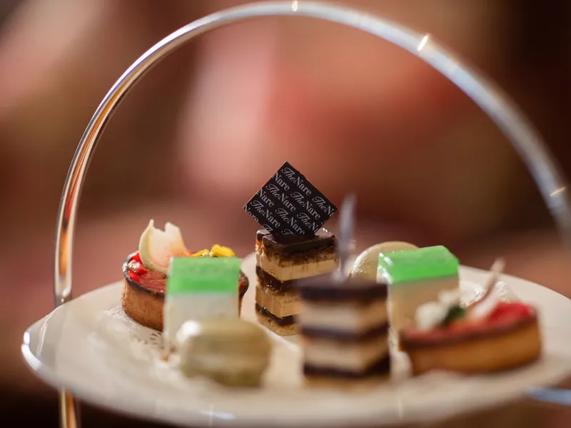 Selection of miniature pastries and cakes on a tiered afternoon tea stand