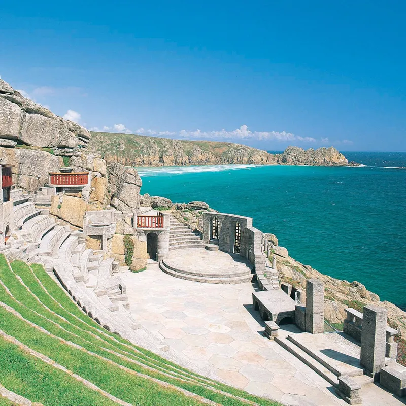 The Minack Theatre carved into cliffs above a turquoise sea in Cornwall