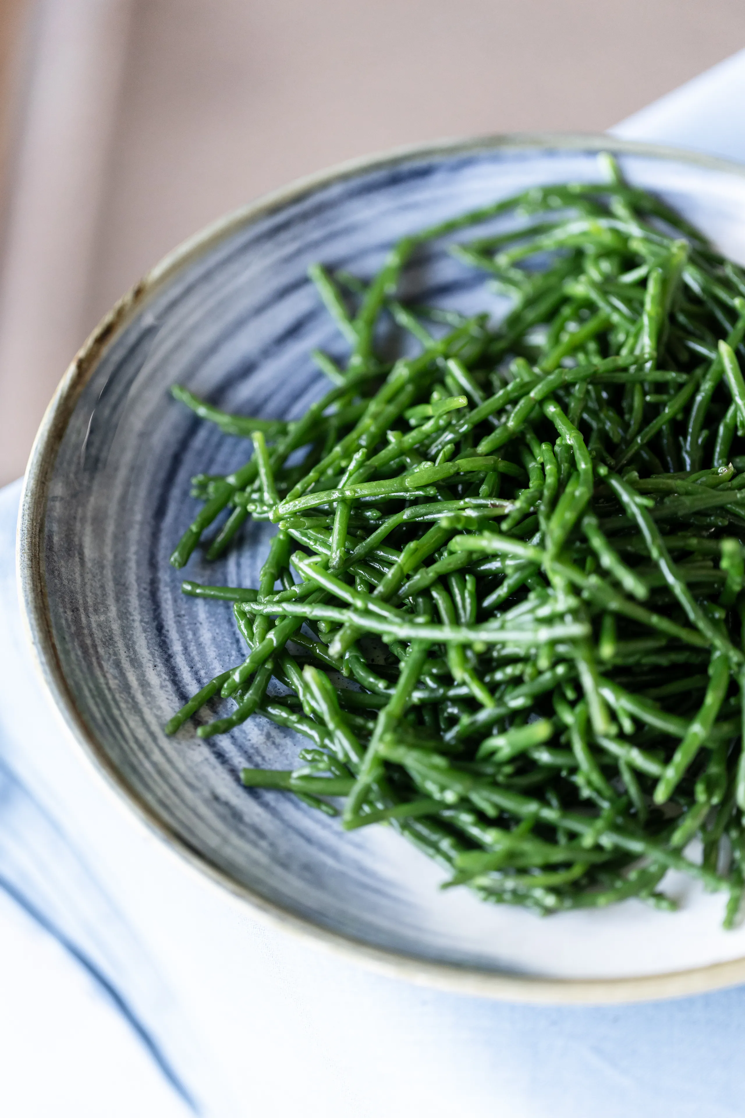 Close-up of fresh samphire in a blue-grey ceramic bowl