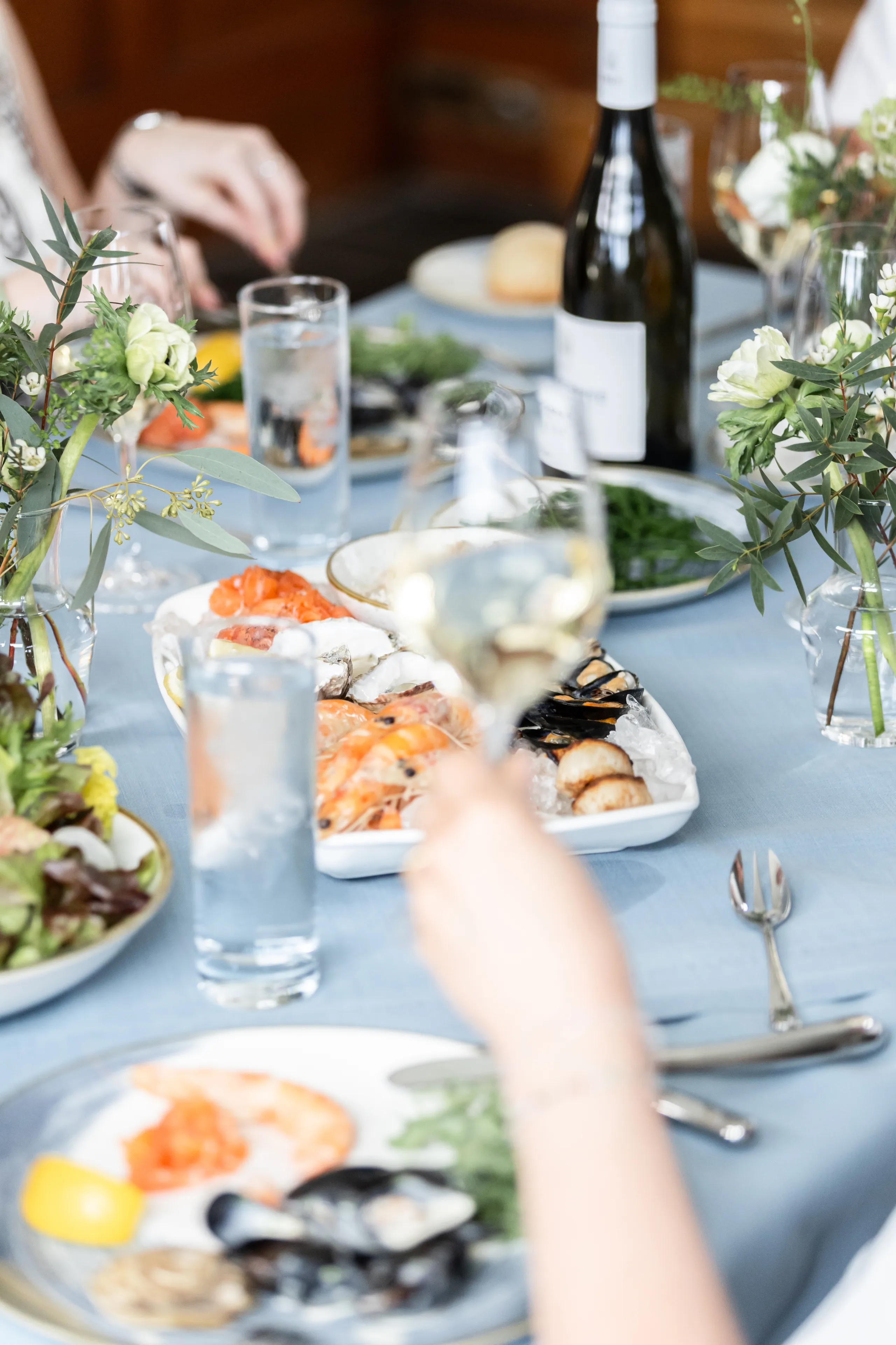 Elegant dining table with a seafood platter, white wine and floral arrangements