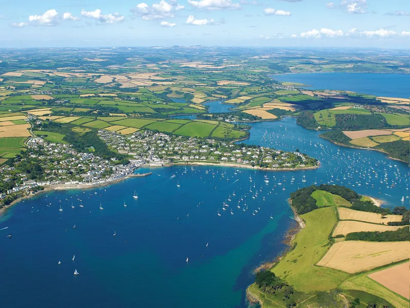Aerial view of the Roseland Peninsula with blue estuary waters, sailing boats and patchwork fields in Cornwall
