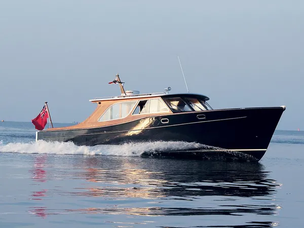 Alice Rose 1 motor yacht cruising across calm water with a dark hull and varnished wooden cabin