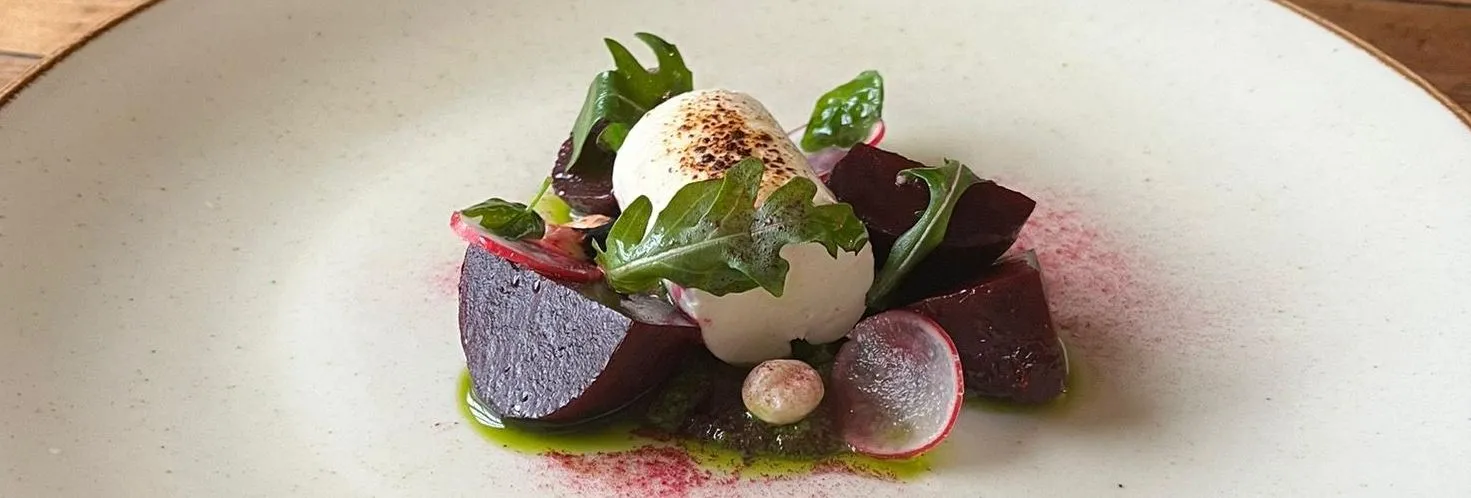 Gourmet beetroot salad with soft cheese, rocket leaves and radish on a ceramic plate