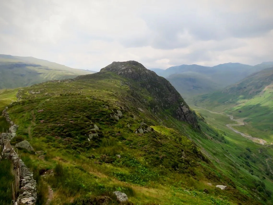 View from Sergeant's Crag across a green rocky ridge and winding valley in the Lake District