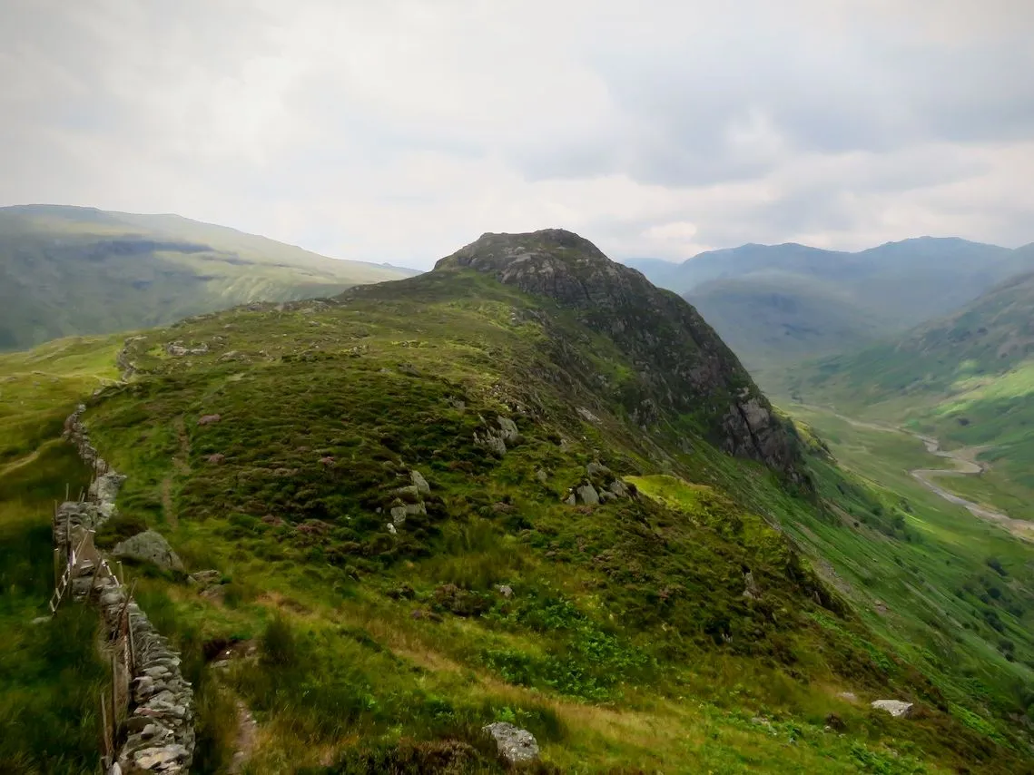 View from Sergeant's Crag across a green rocky ridge and winding valley in the Lake District