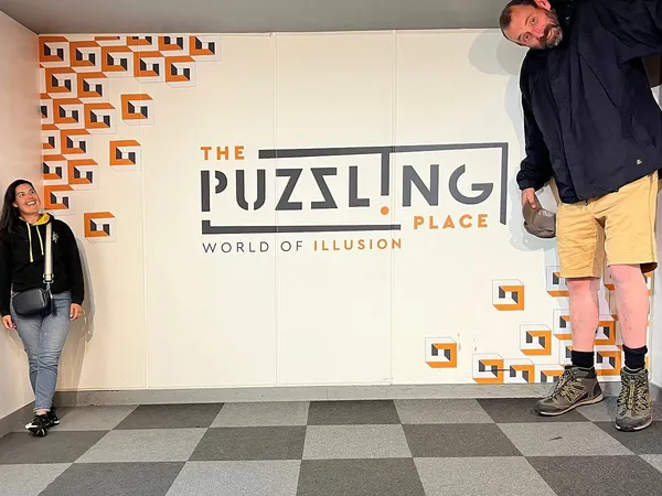 Forced-perspective illusion showing a giant man beside a much smaller woman at The Puzzling Place.