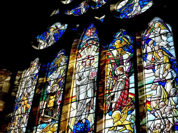 Colorful stained glass window depicting religious figures and scenes in a church