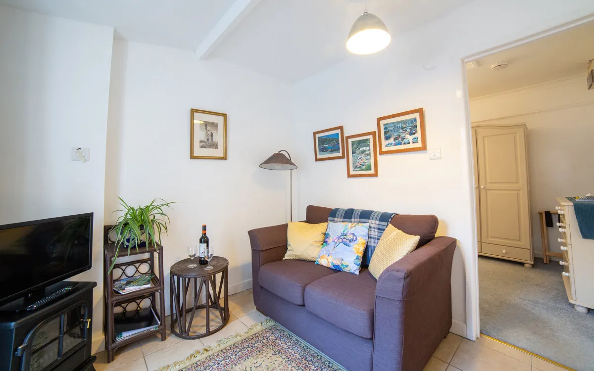 Living room with sofa, tables and tv, with pictures on walls