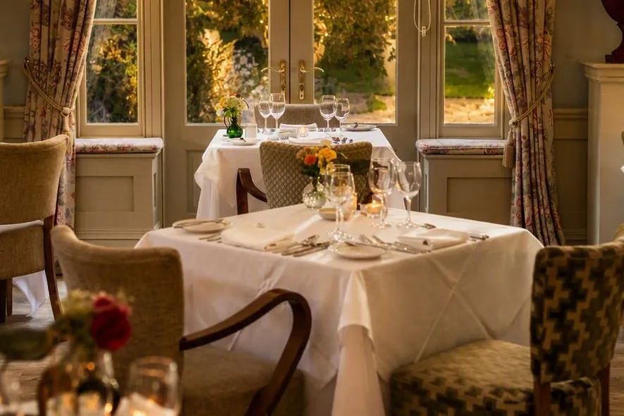 Elegant dining room at Washingborough Hall with twinkling festive lights, white linen tables and a warm seasonal glow.
