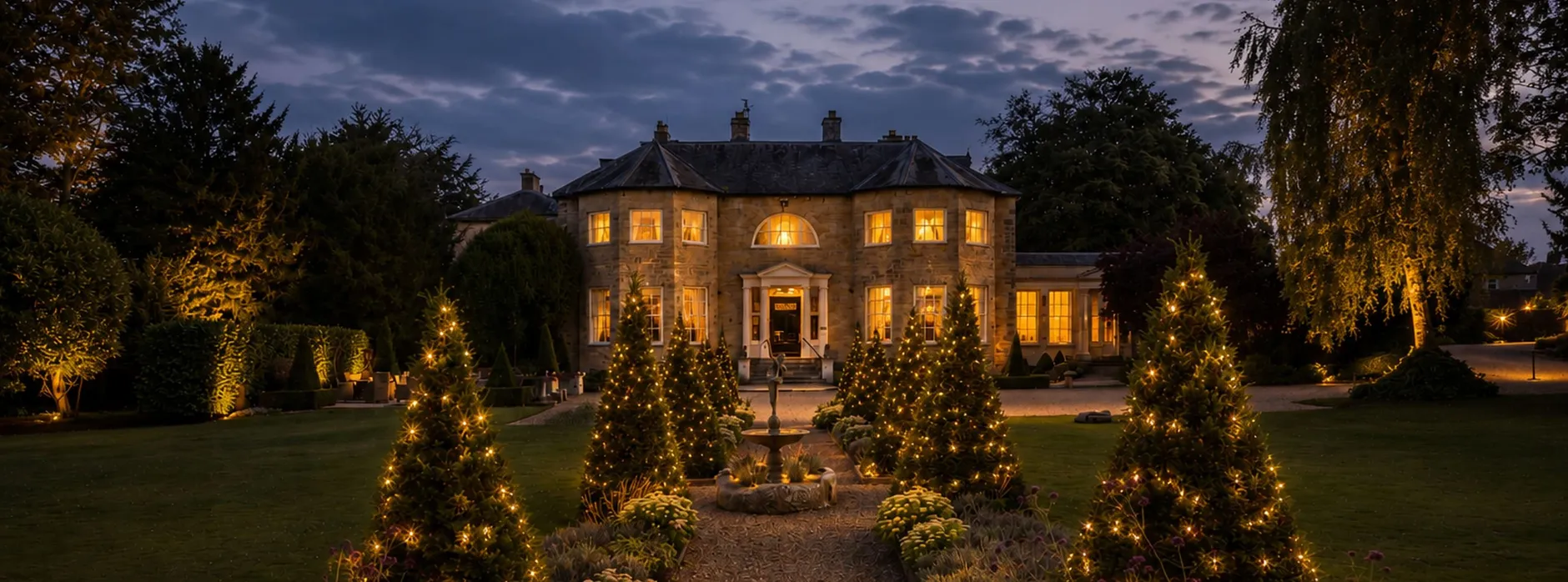 Washingborough Hall at Christmas with twinkling lights, illuminated gardens and the Georgian country house glowing at dusk.